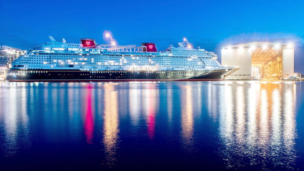 Das Kreuzfahrtschiff „Disney Wish“ liegt Mitte Februar in der Dämmerung am Ausrüstungskai der Meyer-Werft in Papenburg, nachdem es von Schleppern aus dem Baudock gezogen wurde. Foto: Hauke-Christian Dittrich/dpa