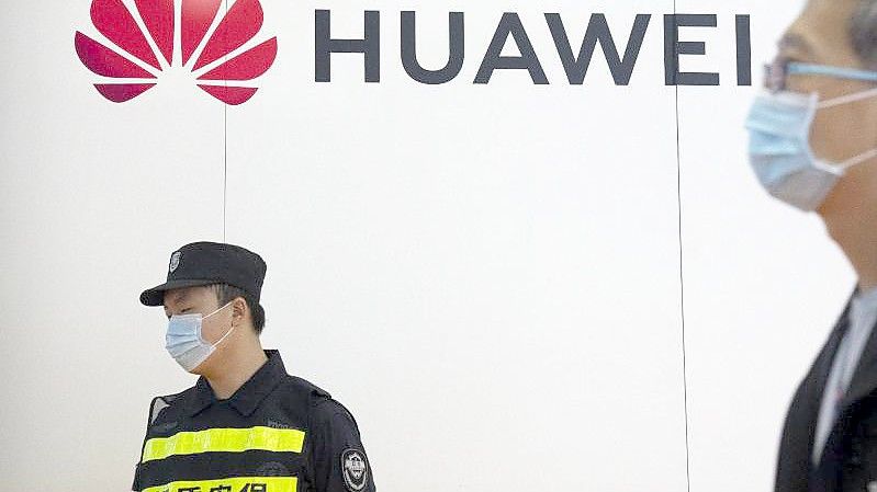 Ein Wachmann steht auf der PT Expo in Peking an einem Stand des chinesischen Technologieunternehmens Huawei. Foto: Mark Schiefelbein/AP/dpa