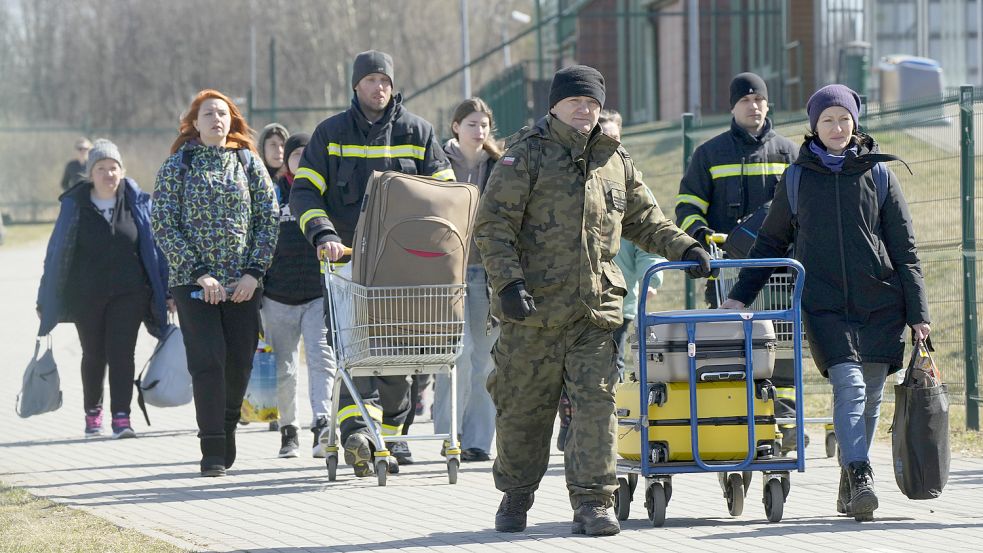Aus der Ukraine geflüchtete Personen kommen am polnisch-ukrainischen Grenzübergang in Medyka an. Foto: Sergei Grits/AP/dpa