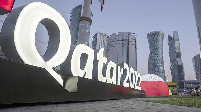 Das Logo der WM in Katar steht vor dem Doha Exhibition and Convention Center, in dem die Auslosung stattfindet. Foto: Darko Bandic/AP/dpa