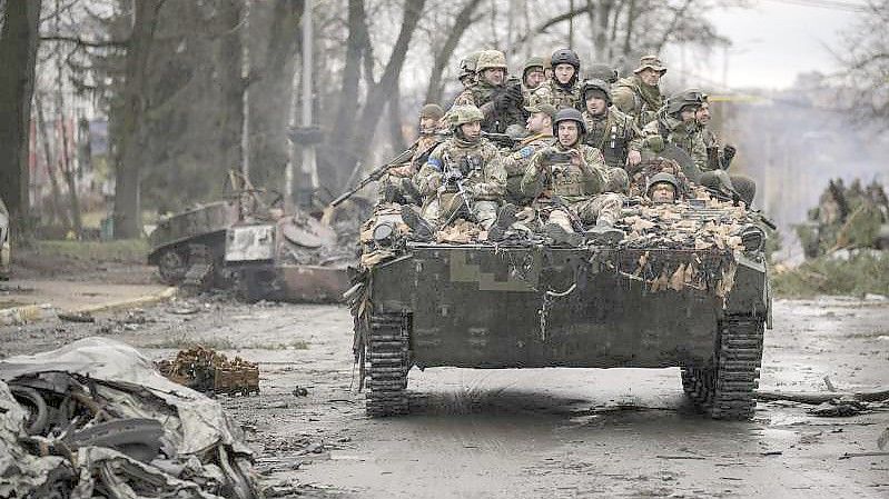 Ukrainische Soldaten fahren durch den Ort Butscha. Dort haben russische Truppen nach angaben von Präsidentenberater Mychajlo Podoljak viele Zivilisten getötet. Foto: Vadim Ghirda/AP/dpa