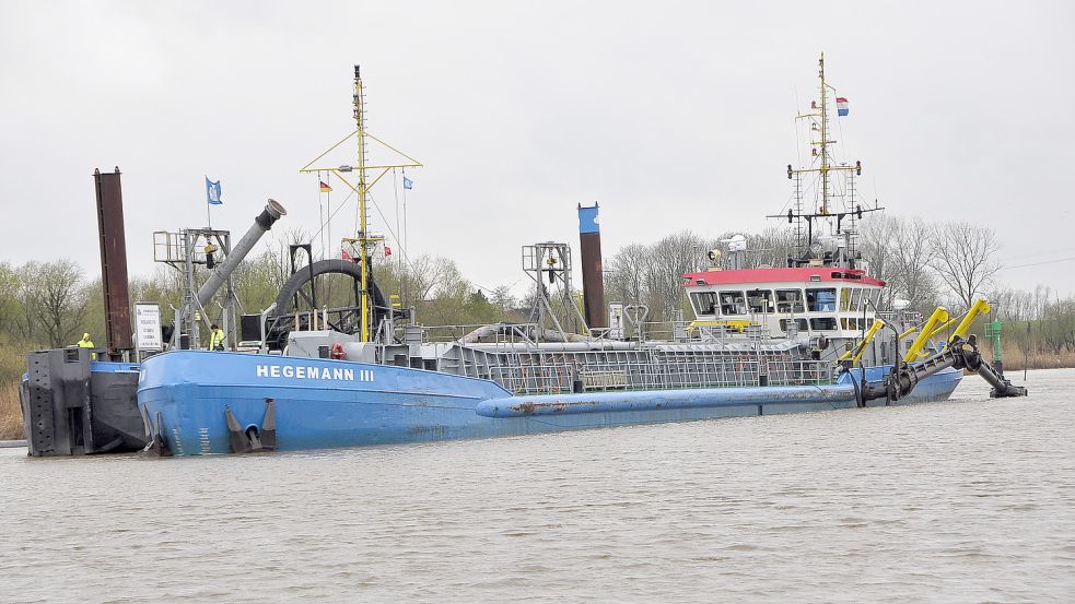 Das Baggerschiff „Hegemann III“ liegt an der Esklumer Leda-Seite und pumpt sein Baggergut über Rohrleitungen ab. Foto: Wolters