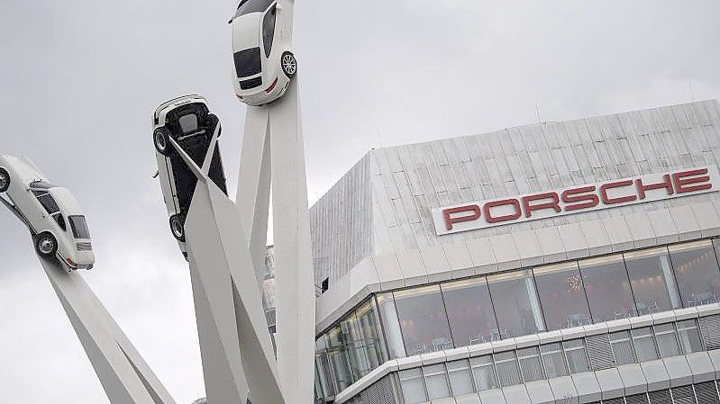 Der Schriftzug „Porsche“ ist auf einem Gebäude des Stammwerkes hinter der Statue „Inspiration 911“. Foto: Sebastian Gollnow/dpa