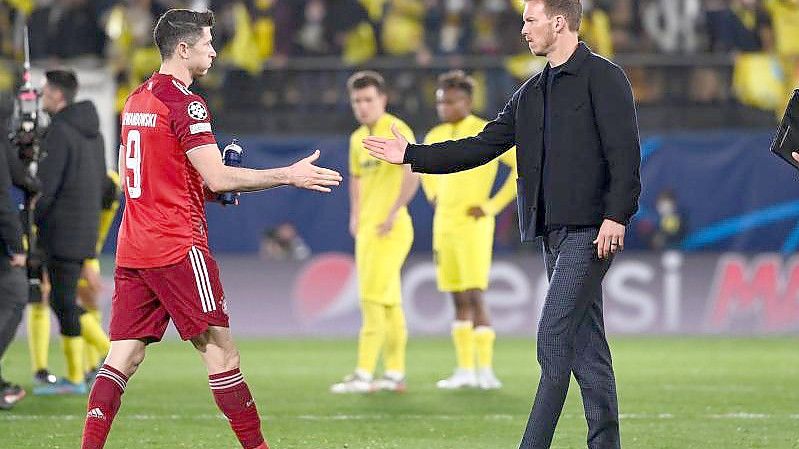 Münchens Trainer Julian Nagelsmann (M) nach dem Spiel in Villarreal beim Handschlag mit Robert Lewandowski. Foto: Sven Hoppe/dpa