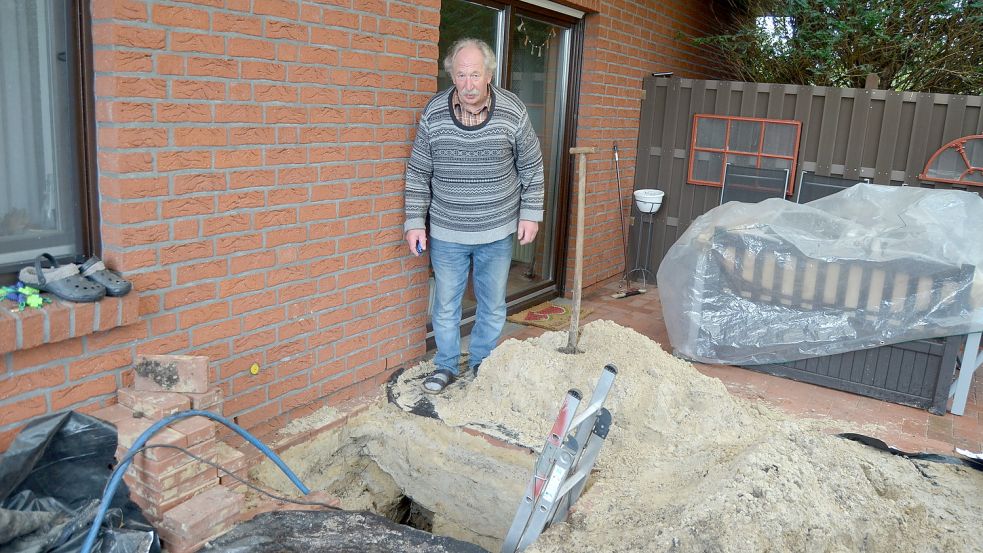 Der Wasserverband hat ein Loch in der Terrasse des Ramsloher Rentners Ludolf Marks gegraben, um zu sehen, wo die Leitung verläuft. Die Leckstelle konnten sie nicht entdecken. Jetzt verlegen sie eine neue Leitung. Aber das Wasser läuft immer noch. Marks pumpt es selber aus der Grube. Fotos: Fertig