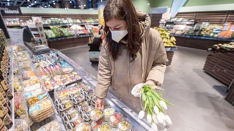 In Supermärkten wurde die Maskenpflicht aufgehoben. Viele Menschen tragen dennoch weiter einen Mund-Nasen-Schutz. Foto: Marijan Murat/dpa