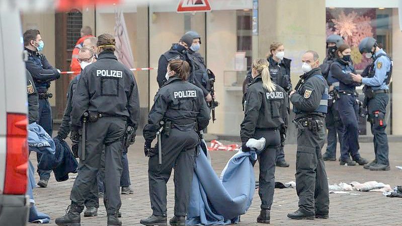 Polizistinnen und Polizisten in Trier am Tatort, wo ein Autofahrer mehrere Menschen erfasst und getötet hat. Foto: Harald Tittel/dpa
