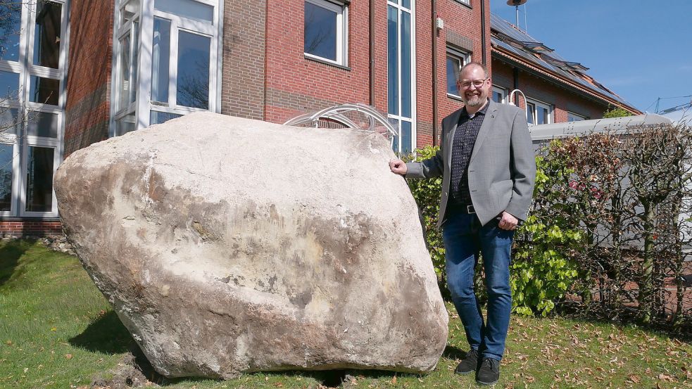 Bürgermeister Thomas Otto neben dem Findling, der nun vor dem Rathaus in Ramsloh liegt. Foto: Kruse