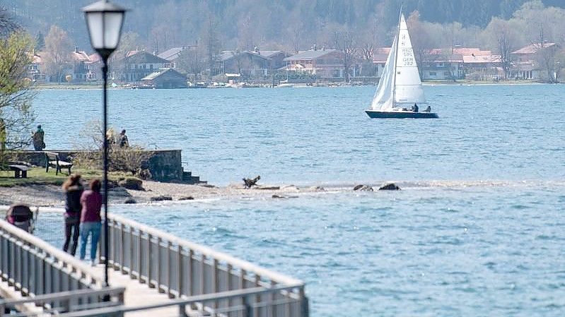 Ein Segelboot fährt in der Sonne über den Tegernsee. Foto: Sven Hoppe/dpa