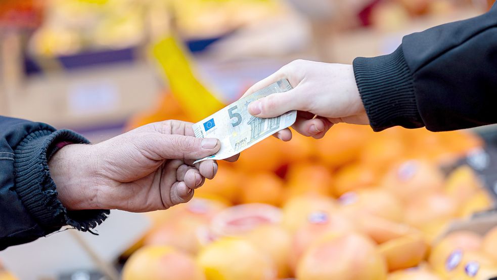 Ein Kunde bezahlt seinen Einkauf an einem Stand auf einem Wochenmarkt. Die Lebensmittelpreise steigen deutlich. Nun gibt es in der EU neue rechtliche Möglichkeiten zur Senkung der Mehrwertsteuer. Foto: Frankenberg/DPA