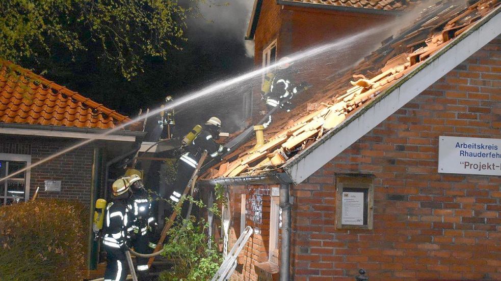 Unter Atemschutz gingen Einsatzkräfte der Feuerwehr am Montagabend gegen die Flammen vor. Der Dachstuhl des Gebäude eines Jugendbauernhofes des Arbeitskreises Schule Rhauderfehn (AKSR) in Burlage wurde durch das Feuer stark beschädigt. Foto: Ammermann