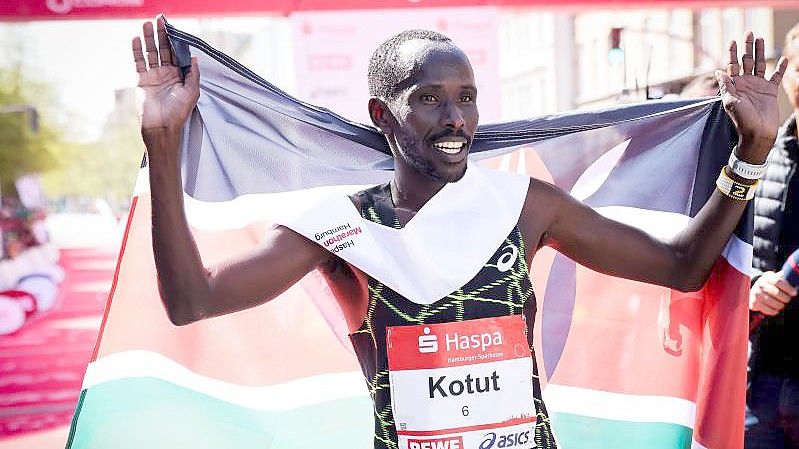 Der Kenianer Cybrian Kotut aus Kenia feiert seinen Sieg in Streckenrekordzeit beim Hamburg-Marathon. Foto: Christian Charisius/dpa