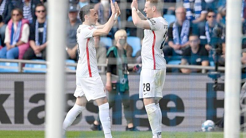 Augsburgs Ruben Vargas (l) und Andre Hahn klatschen nach dem 1:0 ab. Foto: David Inderlied/dpa