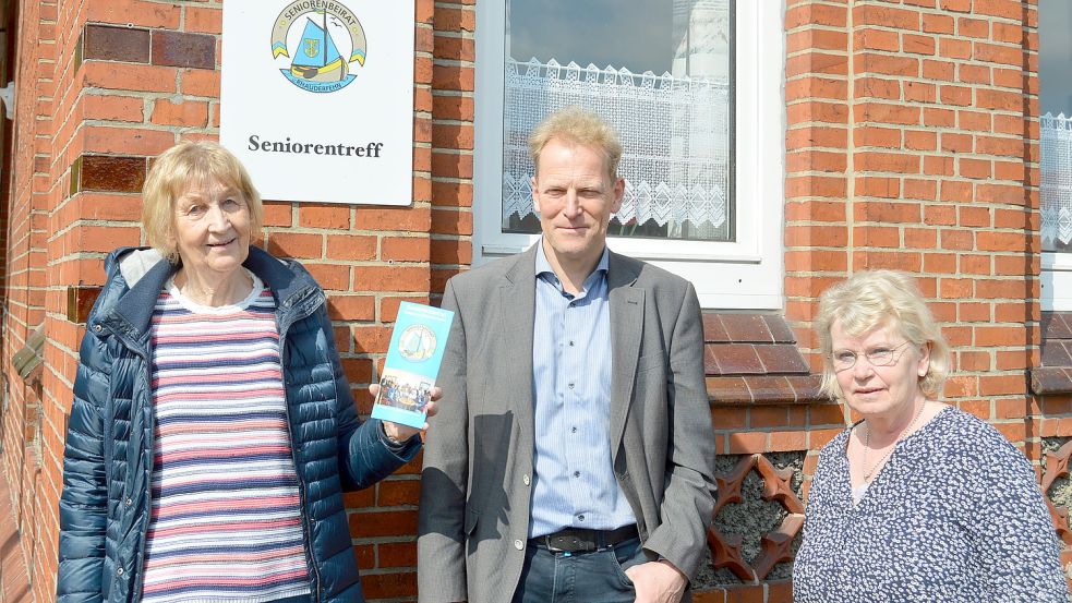 Griet Luikenga-Gerdes (links) und Margarethe Niemann (rechts) stehen mit Rhauderfehns Bürgermeister Geert Müller am Eingang zum Seniorentreff an der 1. Südwieke. Foto: Weers