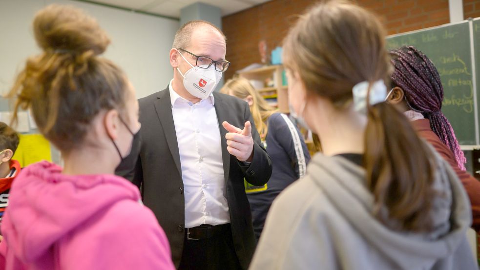 Kultusminister Grank Hendrik Tonne (SPD), hier beim Besuch einer Schule in Hannover im Februar, plädiert dafür, die Schüler nicht mit Masken- und Testpflicht zu belasten. Foto: Stratenschulte/DPA