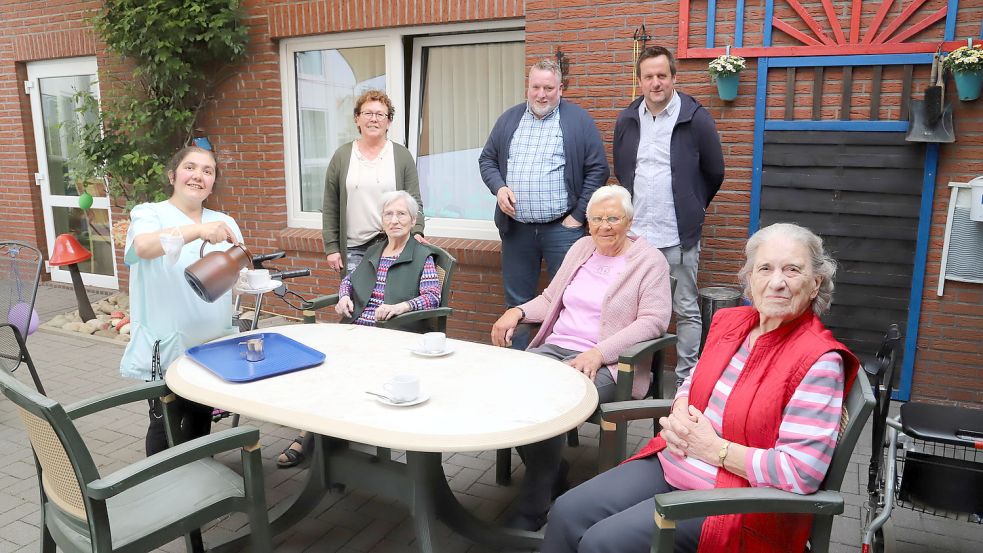 Nachgestellt für die Presse eine der Tätigkeiten von Mezgine Akbulut, die auch Kaffee serviert im Wohn- und Pflegeheim „to Huus“, hier an Helga Stolz, Helene Pettendrup und Ingrid Klein. Hauswirtschaftsleiterin Adelheid Kassens (stehend, von links) und die Job-Trainer Ludger Reil und Jörg Stratmann freuen sich über die gelungene Integration in den regulären Arbeitsmarkt. Foto: Kruse