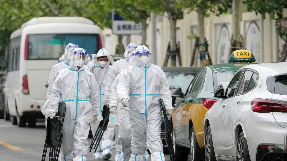 Arbeiter des Gesundheitswesens sind auf dem Weg zu einem abgesperrten Wohnkomplex in Peking. Viele Millionen Menschen vor allem im Nordosten Chinas sind seit mehr als einem Monat im Lockdown. Foto: Andy Wong/AP/dpa