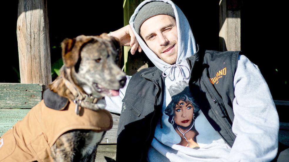 Der Influencer Fynn Kliemann sitzt mit seinem Hund auf dem Hof „Kliemannsland“ im Kreis Rotenburg (Wümme). Die Kreativstätte des Unternehmers wird von der EWE mit grünem Strom aus Ostfriesland versorgt. Foto: Dittrich/DPA