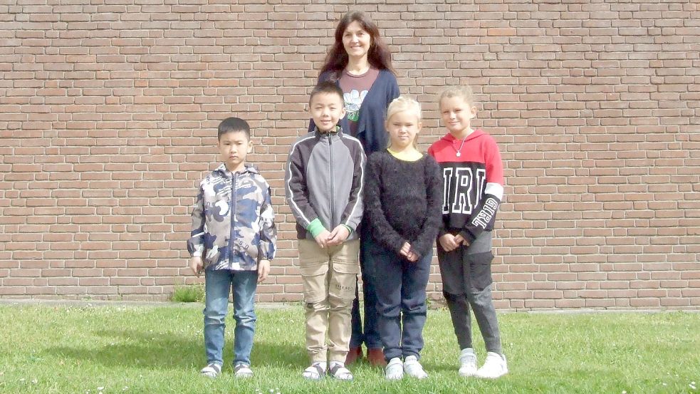 Lehrerin Elena Peters von der Grundschule in Langholt mit den Flüchtlingskindern (von links) Schon, Tom, Safina, und Marianna.