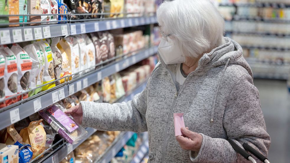 Gerade ältere Menschen tragen beim Einkauf häufig noch Maske, beobachtet die Mitarbeiterin eines Supermarktes in Jemgum. Foto: Murat/DPA