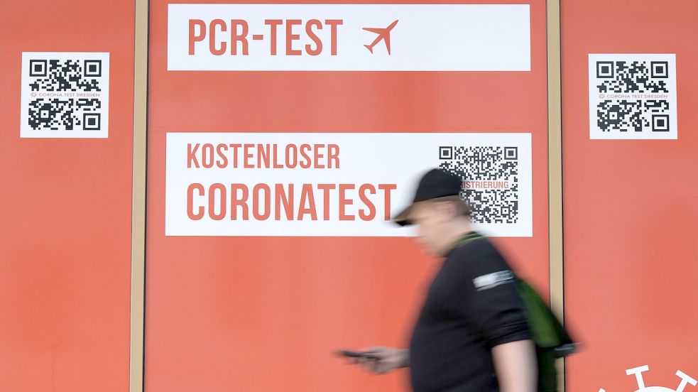 Ein Passant geht an einem Corona-Testcenter in Dresden entlang. Foto: Sebastian Kahnert/dpa