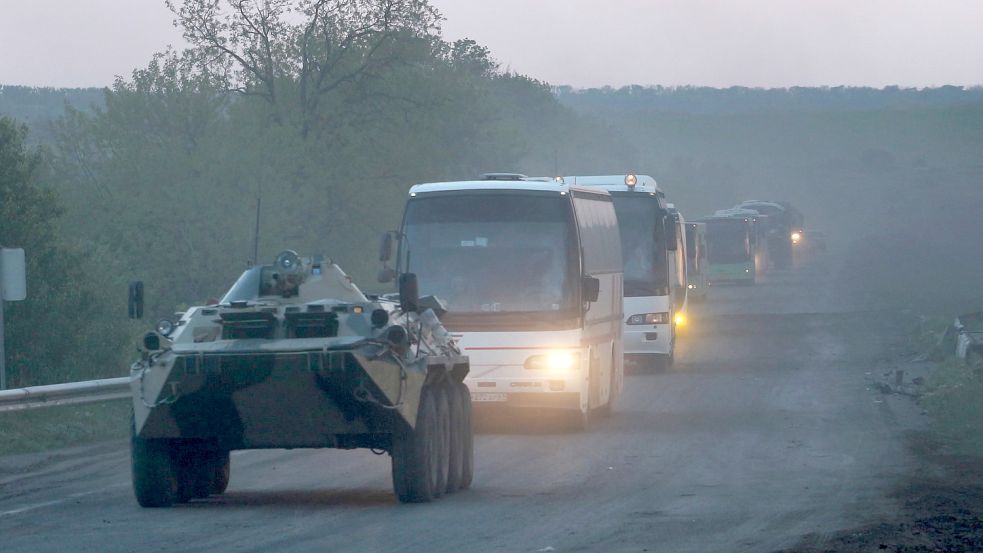 Ein APC der Miliz der sogenannten Volksrepublik Donezk begleitet Busse mit ukrainischen Soldaten zur Strafkolonie in Oljoniwka, nachdem sie das belagerte Stahlwerk Azovstal in Mariupol verlassen haben. Foto: Uncredited/AP/dpa