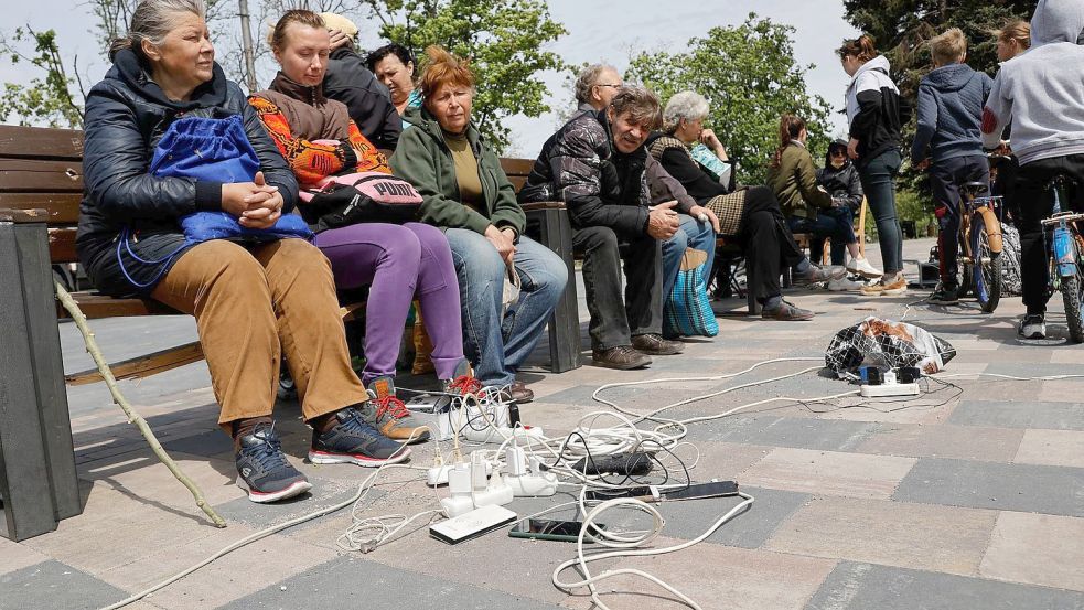 Menschen in Mariupol laden ihre Telefone auf - das Gebiet in der Ostukraine steht unter der Regierung der sogenannten Donezker Volksrepublik. Foto: Alexei Alexandrov/AP/dpa