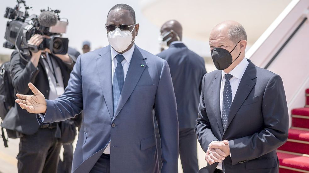 Bundeskanzler Olaf Scholz (r, SPD), wird von Macky Sall, Präsident der Republik Senegal mit militärischen Ehren am Flughafen begrüßt. Foto: Michael Kappeler/dpa