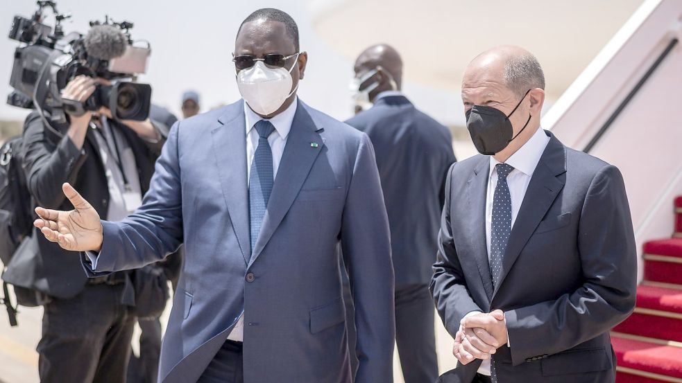 Bundeskanzler Olaf Scholz (r, SPD), wird von Macky Sall, Präsident der Republik Senegal mit militärischen Ehren am Flughafen begrüßt. Foto: Michael Kappeler/dpa