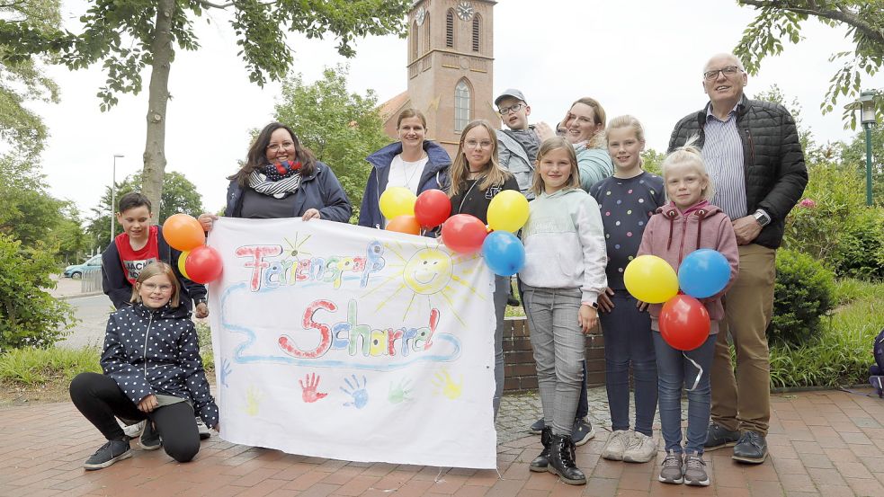 Freuen sich über das Ferienspaß-Angebot in Scharrel: die Organisatorinnen Kathrin Müller-Valentin (von links), Andrea Büter und Tina Griep zusammen mit dem Gemeindeausschuss-Vorsitzenden Georg Pugge und Kindern. Foto: Passmann