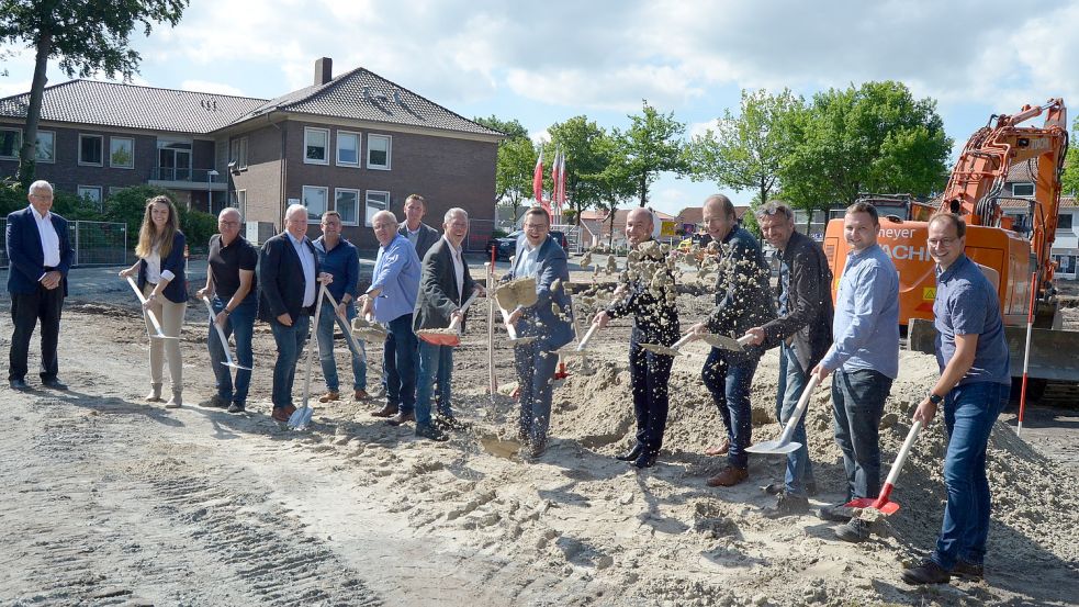Vor dem jetzigen Rathaus, das dem Neubau weichen wird, stießen etliche am Projekt Beteiligte am Mittwoch einen Spaten zum symbolischen ersten Spatenstich in den aufgeschütteten Sand auf der Baustelle: (von links) CDU-Ratsherr Hans Eveslage, die Bautechnikerin der Gemeinde, Maja Peters, Personalratsvorsitzender Armin Flügge, CDU-Ratsherr Jörg Kleemann, Herbert Schmidt von der für die Haustechnik zuständige Firma Vorpahl, Erster Gemeinderat Michael Sope, CDU-Ratsherr Johannes Geesen, SPD-Ratsherr Heino Willhaus, Barßels Bürgermeister Nils Anhuth, der für die Planung zuständige Architekt Matthias Schneider aus Stuttgart, die für die Bauleitung zuständigen Architekten Christian Bär und Wolfgang Franz sowie Julian Hoft von ihrer Sozietät und der Projektleiter im Barßeler Rathaus, Markus Wiechmann. Foto: Fertig
