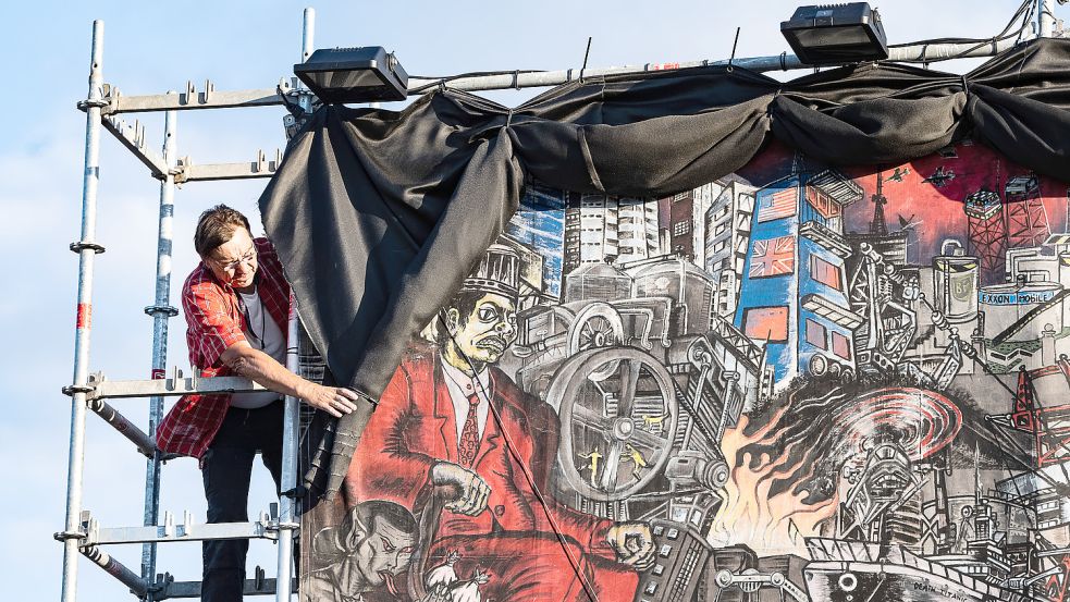 Ein Mitarbeiter der Documenta 15 verhüllt das großflächige Banner „People’s Justice“ des Kollektivs Taring Padi. Aufgrund einer Figurendarstellung des Kollektivs, die antisemitische Lesarten ermöglicht, habe sich das Kollektiv gemeinsam mit der Geschäftsführung und der Künstlerischen Leitung „entschieden, die betreffende Arbeit zu verdecken und eine Erklärung dazu zu installieren“, teilte die Documenta am Montagabend mit. Foto: Pförtner/DPA
