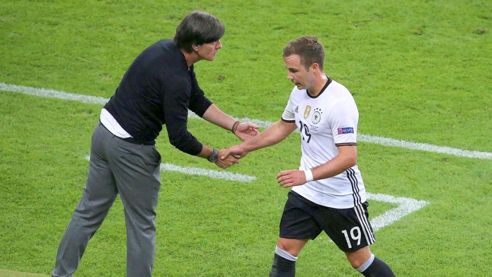 Bei der EM 2016 gibt der damalige Bundestrainer Joachim Löw (l) Mario Götze bei dessen Auswechslung die Hand. Foto: Srdjan Suki/EPA/dpa