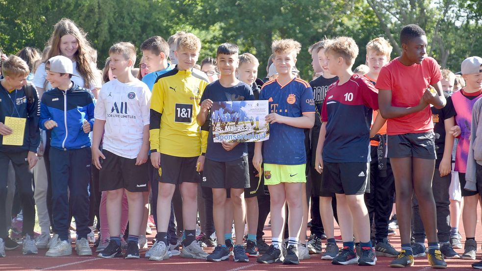 Kurz vor dem offiziellen Start auf dem Sportplatz der Schule Collhusen wurde noch einmal das Plakat des gemeinsamen Sponsorenlaufs des Schulzentrums Collhusen und der Schule am Patersweg gezeigt. Foto: Ammermann