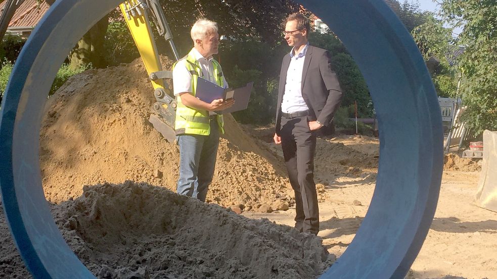 Burkhard Wilts (links) und Timo Kramer diskutieren auf der Baustelle den weiteren Ablauf. Das Rohr im Vordergrund gehört zum neuen Kanal. Foto: Mielcarek