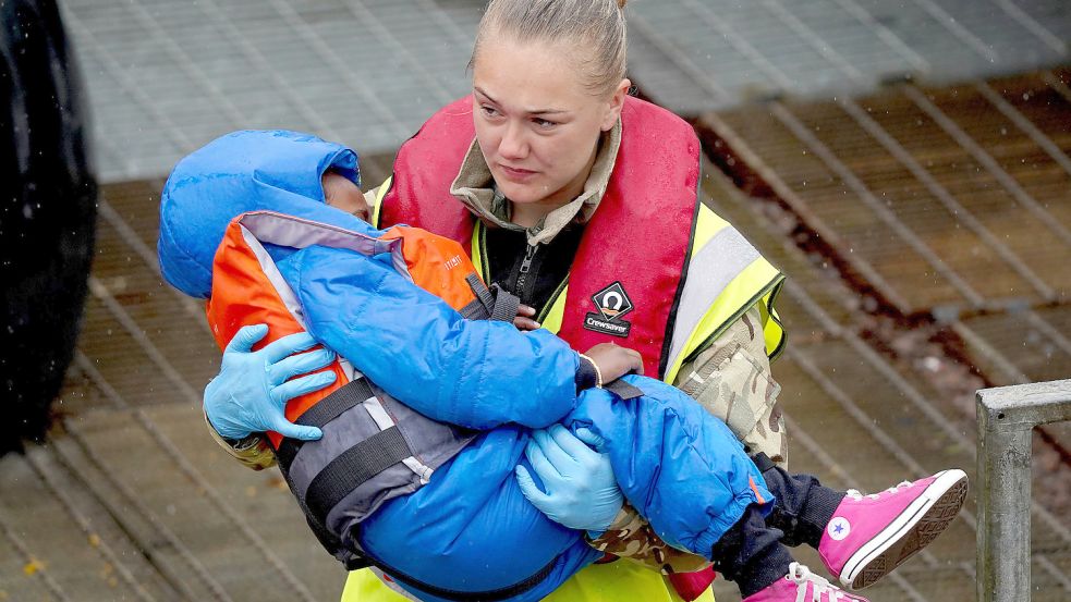 Drama ohne Ende: Ein Kind, das mit einem Schleuserboot den Ärmelkanal überquert hat, in den Armen einer britischen Mitarbeiterin des Militärs. Foto: Gareth Fuller