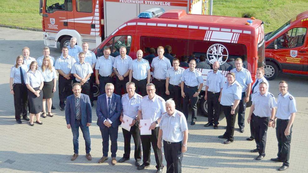Im Vordergrund: Florian Tautrich (Ordnungsamtsleiter der Gemeinde Westoverledingen, Bürgermeister Theo Douwes, Joachim Lassahn, Frank Harms und Heino Veenekamp. Im Hintergrund sind Feuerwehrkameradinnen und Kameraden der Wehren der Gemeinde zu sein. Foto: Weers