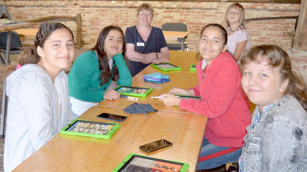 Unter Anleitung von Birgit Hedemann (3. von links) entwickeln in der Museumsscheune im Moor- und Fehnmuseum die Schülerinnen Amine (von links), Rasan, Sophie, Güle und Diana ihre eigenen Comics auf dem iPad. Fotos: Fertig