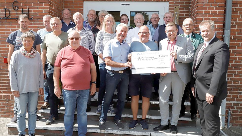 Gut gelaunt hält Bürgermeister Nils Anhuth (3. von rechts) den Scheck über 10.000 Euro in Händen, den Veranstalter Claas Meyer (4. von rechts) an das Flohmarktgremium übergab. Foto: Passmann