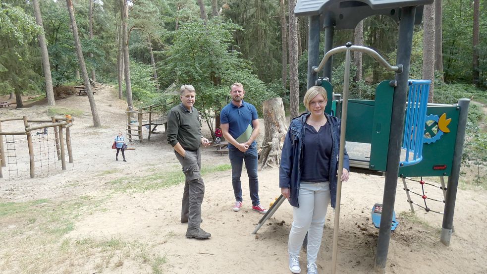 Bürgermeister Gerd Dählmann (von links) sowie Andy Treyßel und Andrea Nannen von der Gemeinde Hesel stehen vor einem der neuen Spielgeräte im Heseler Wald. Foto: Rümmele