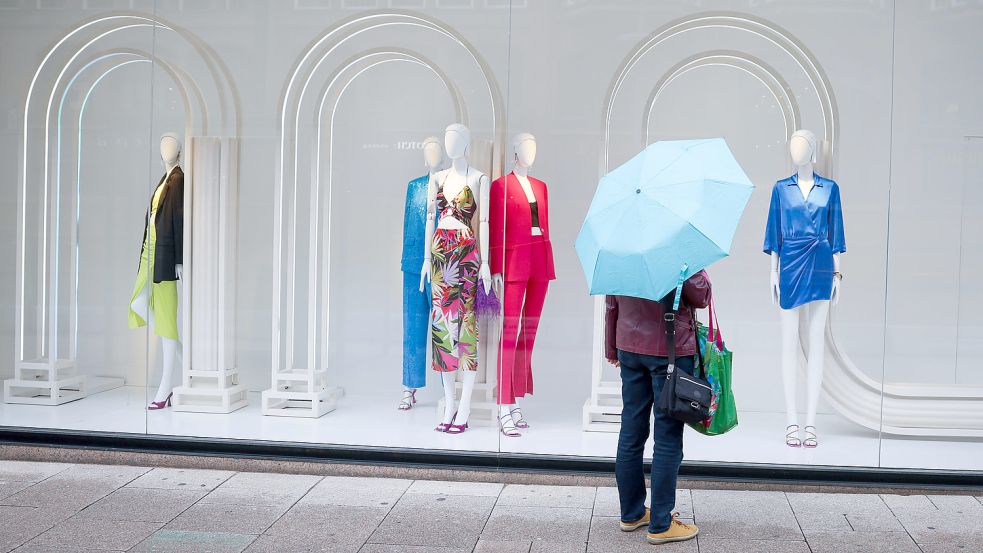 Eine Passantin steht in der Hamburger Innenstadt vor einem Schaufenster. Die hohe Inflation hat die Geschäfte des Einzelhandels in Deutschland im Juni deutlich belastet. Foto: Charisius/DPA