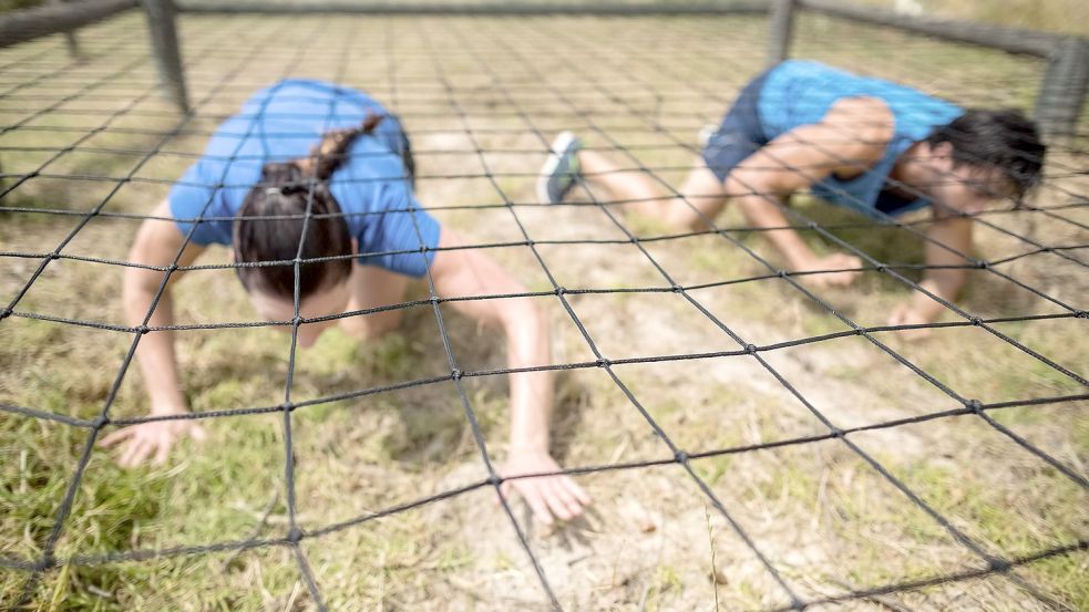 Wer den Wettbewerb um den Ostfriesland-Warrior gewinnen will, muss unter anderem unter einem Netz hindurchkriechen. Symbolfoto: WavebreakMediaMicro/stock.adobe.com