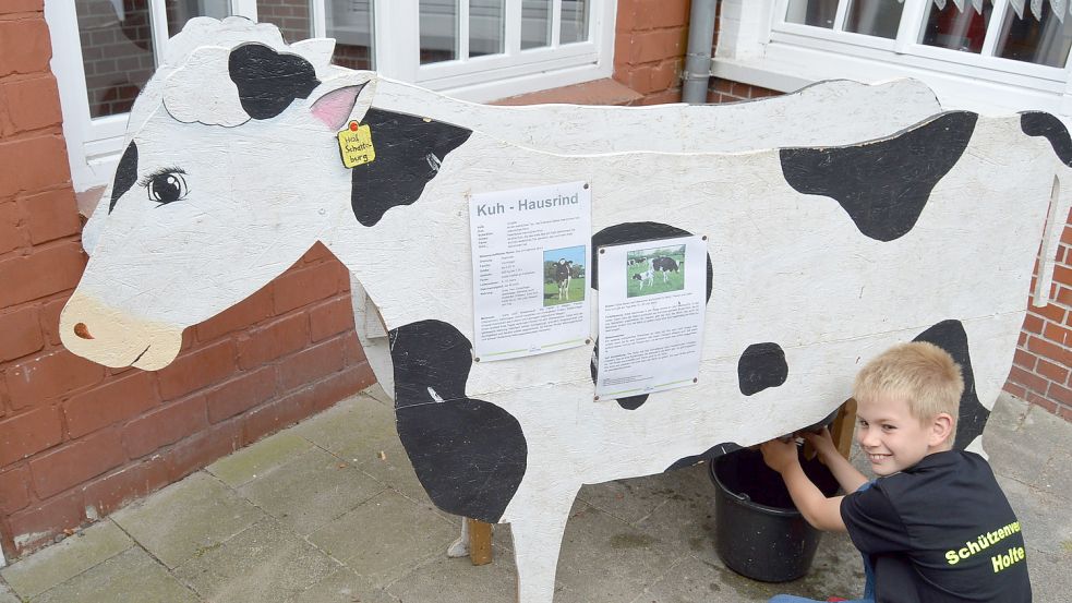 Die Holter Landjugend bot im Rahmen des Dorffestes ein Spiel an, bei dem Kinder eine Holzkuh „melken“ konnten. Hier versucht sich der neunjährige Jelto. Foto: Weers