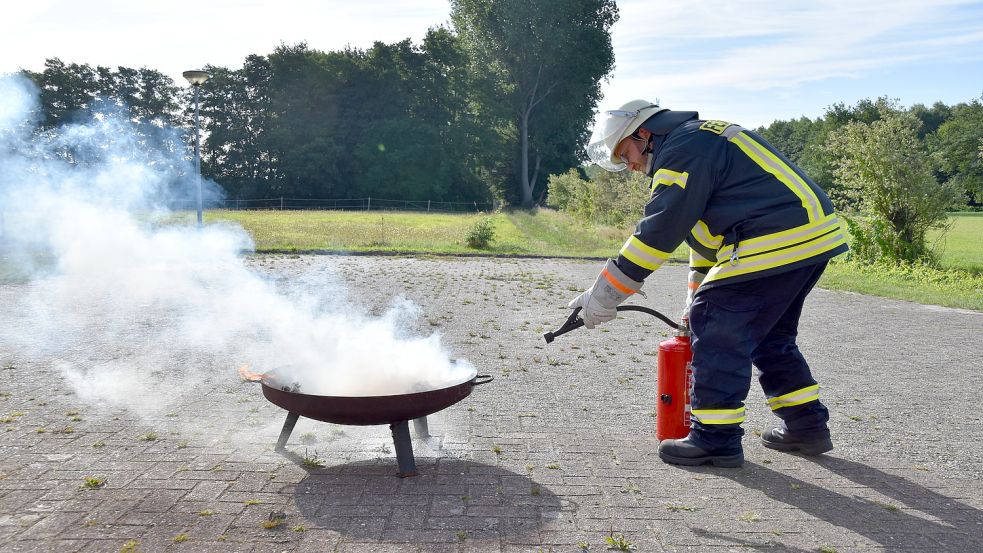 Mit mehreren Stößen soll das Feuer gelöscht werden. Gemeindefeuerwehrsprecher Markus Bruns macht es vor. Foto: Wehry