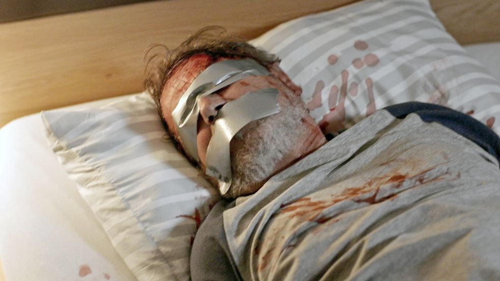 Filmszene aus der Aktenzeichen-Sendung, in der der Fall aus Hüven nachgestellt wurde: Das Opfer, ein 67-jähriger Autohändler, wurde von den Tätern massiv geschlagen und gefesselt und geknebelt zurückgelassen. Weil der Mann blutverdünnende Medikamente einnahm, erlitt er einen solch intensiven Blutverlust, dass sein Leben am seidenen Faden hing.