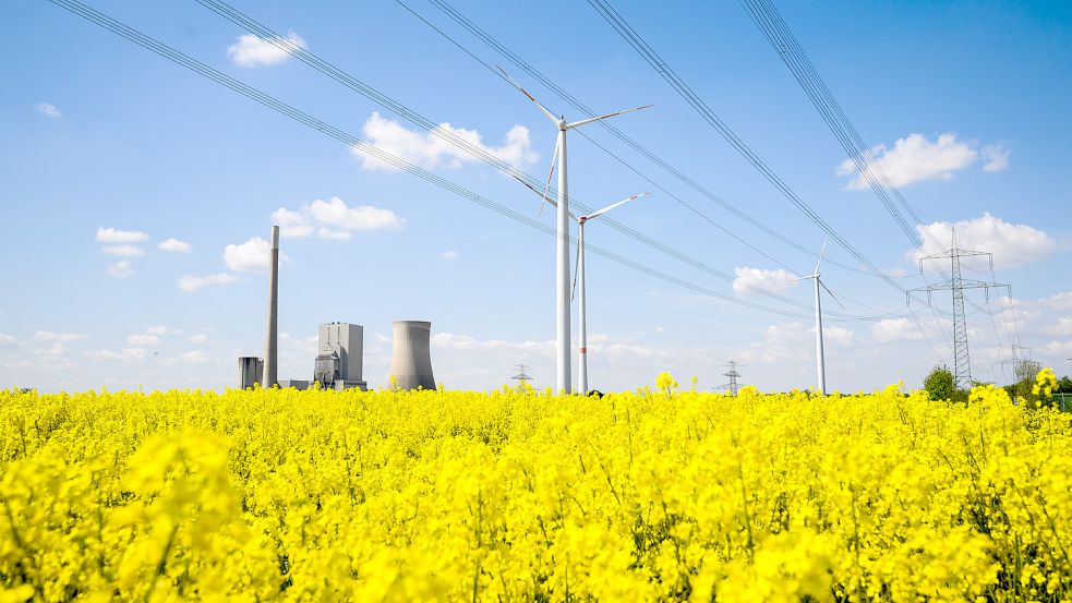 Energiewende auf einen Blick: Windräder, eine Hochspannungsleitung und das stillgelegte Kohlekraftwerk Mehrum. Niedersachsens Energiewirtschaft fordert eine deutlich schnellere Umsetzung von Projekten zum Umbau der Energieversorgung wie den Bau von Windkraftanlagen und Stromtrassen. Foto: Stratenschulte/dpa