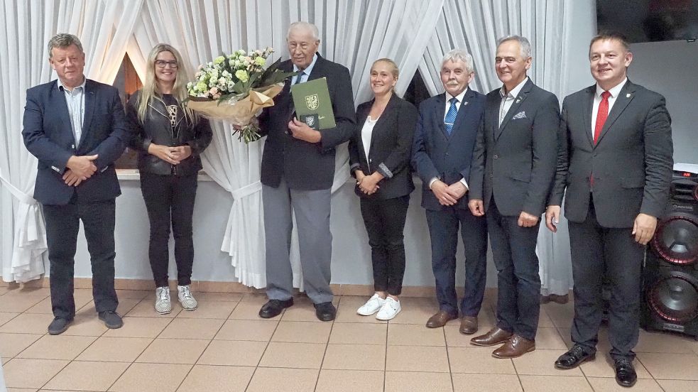 Der Saterländer Conrad Niemeyer mit Urkunde und einem großen Blumenstrauß anlässlich der Verleihung der Ehrenbürgerwürde im Kreis kommunaler Vertreter von Sroda Slaska, darunter Bürgermeister Adam Rucinski (rechts) und seinem Amtsvorgänger Boguslaw Krasucki (3. von rechts). Foto: privat