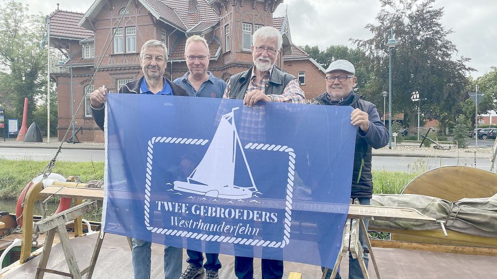Die vierköpfige Crew hat drei neue Mitglieder: (von links) Artur Becker, Karl Schäper und Dr. Rüdiger Canders. Erhard Meiners (rechts) ist seit 2018 dabei. Sie zeigen die neue Flagge des Museumsschiffs. Foto: Hagewiesche