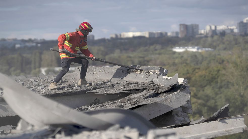 Ukraine, Charkiw: Ein Mitarbeiter des Rettungsdienstes säubert das Dach eines Wohnhauses, das bei einem Angriff beschädigt wurde, von Trümmern und instabilen Strukturen, die einstürzen könnten. Foto: Leo Correa/AP/dpa
