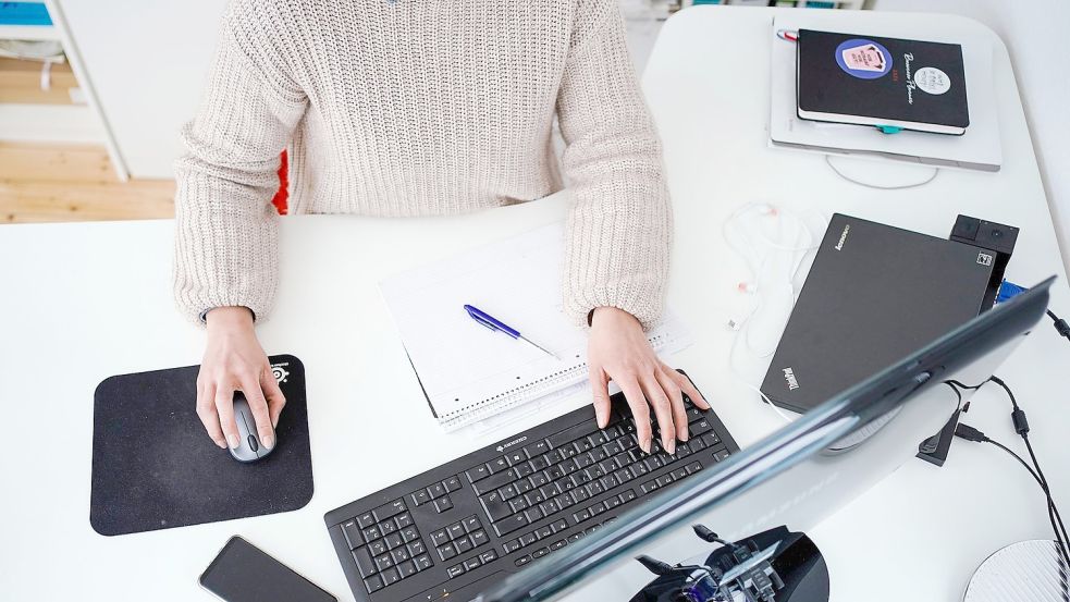 Eine Frau arbeitet vor einem Computer an einem Stehtisch. Foto: Uwe Anspach/dpa